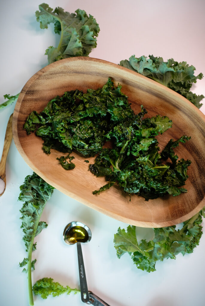 Kale chips in a bowl made with olive oil and salt. This is a healthy snack idea. 